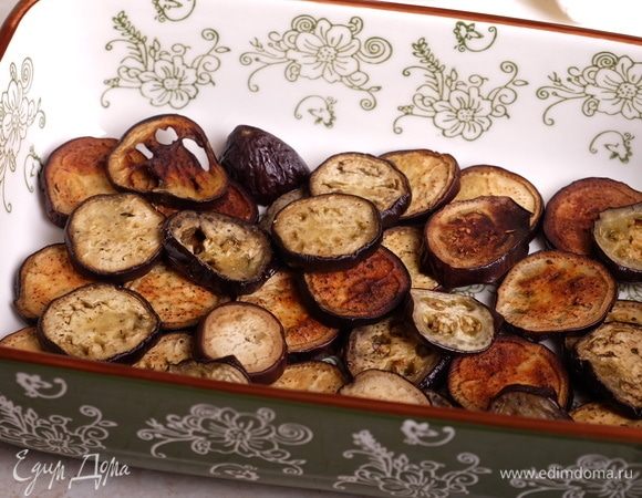 Духовку разогреть до 200°С. На дно формы выложить треть баклажанов.