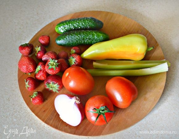 Помыть, подготовить клубнику и овощи. Очистите от шелухи половинку средней луковицы. Помидоры необходимо очистить от шкурки, клубнику — от чашелистиков, с перца срежьте крышечку и освободите от семечек, с огурцов срежьте хвостики.