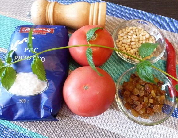 Подготовим продукты для фаршированных помидоров. Лук мелко-мелко нарубим, петрушку и мяту мелко нарежем. Изюм без косточек помоем, если он слишком сухой, то замочить в горячей воде на 5 минут. Кедровые орехи подсушить на сухой сковороде.