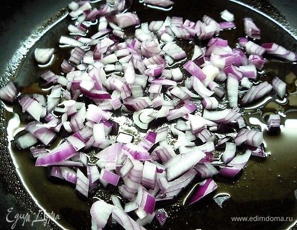 В сковороду наливаем оливковое масло, добавляем мелко нарезанную красную луковицу и обжариваем до прозрачности.