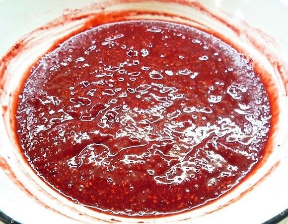 Высыпаем малину в чашку и пюрируем с помощью блендера. Протираем через сито, чтобы убрать часть косточек.