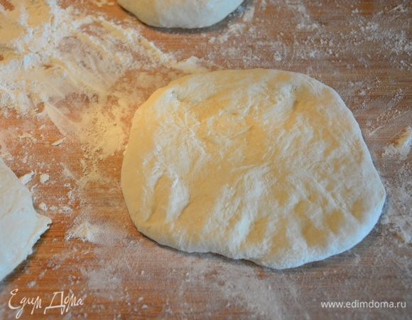 Растянуть тесто руками в небольшой пласт.