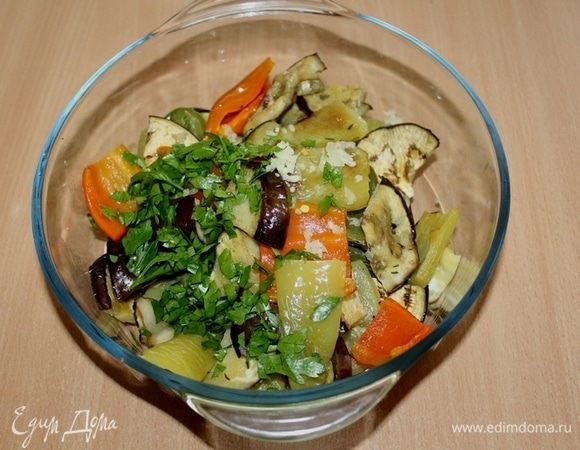 Вынуть овощи из духовки, добавить измельченный чеснок и зелень, посолить, поперчить по вкусу, приправить оливковым маслом. Перемешать.