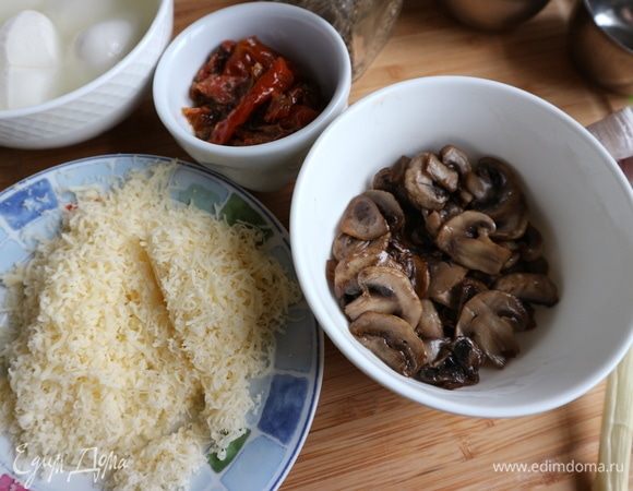 Чеснок почистить, раздавить плоской стороной ножа, немного поджарить на оливковом масле, чтобы чеснок отдал свой аромат, вынуть чеснок, а на сковороду положить шампиньоны,  нарезанные пластинами, поджарить. Пармезан натереть на мелкой терке.