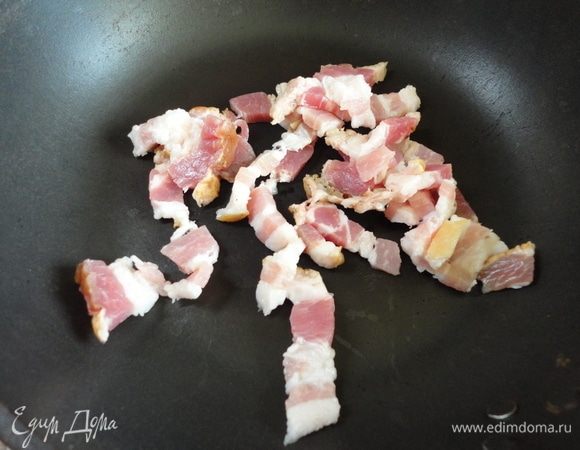 Бекон нарезать тоненькими полосками и обжарить на сухой сковороде.