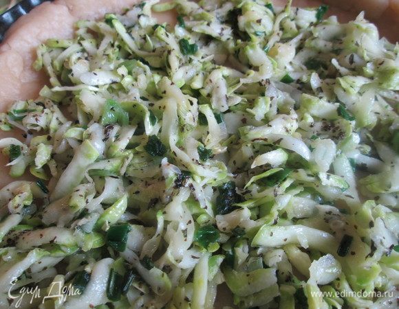 Приготовим заливку для тарта: взбиваем яйца и сливки, добавляем перец, соль, мускатный орех, мяту и кабачки. Все перемешиваем и выливаем на корж. Сверху кладем козий сыр или творог. Выпекаем при 190°С 25 минут. Готовый пирог посыпаем зеленью.