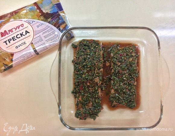 Затем, положите рыбу в форму для выпекания и распределите по ней маринад таким образом, чтобы он глубоко проникал в получившиеся разрезы. Оберните пищевой пленкой и оставьте промариноваться на час.