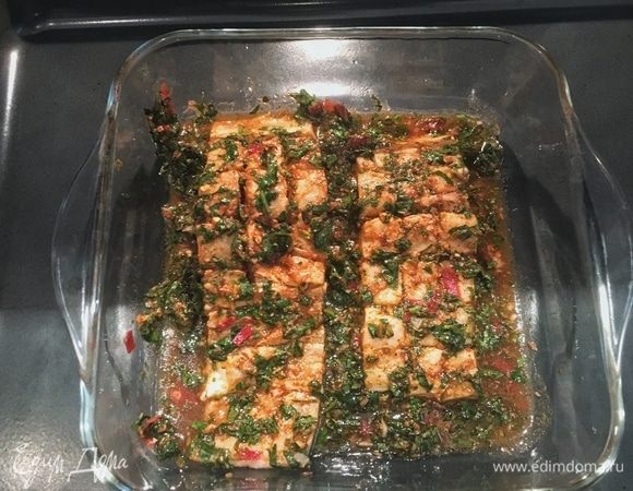 Разогрейте духовку до 200°С. Снимите с формы пленку. Уберите с филе излишек зелени от маринада, чтобы рыба стала еще красивее при запекании. Поставьте треску на 15-20 минут. 