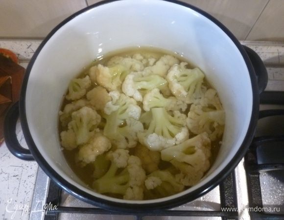 Если берете сухой нут, то предварительно замочите его на ночь. Нут нужно промыть и отварить в течение 1-1,5 ч. Воду слить.
Цветную капусту разобрать на соцветия. Отварить в подсоленной воде до полуготовности (6-8 минут). Откинуть на дуршлаг и переложить в форму для запекания.