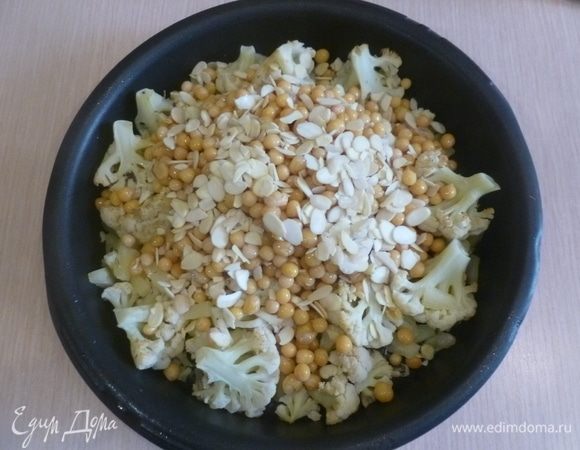 Капусту достать из духовки, перевернуть, добавить миндаль и нут. Поставить в духовку еще на 10 минут.