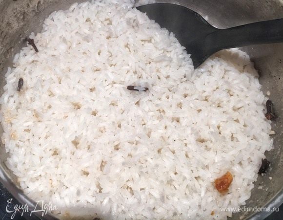 Снимите крышку. Вода полностью впиталась. Уберите гвоздику и чили из риса. Перемешайте. Выключите огонь под кастрюлей и накройте ее крышкой. Рис готов.
