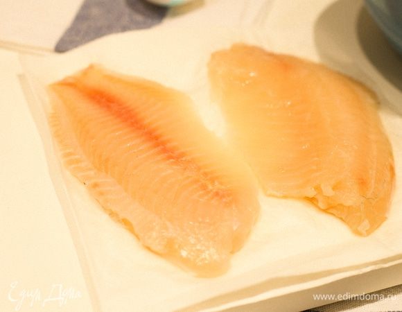 Размороженное филе рыбы (в моем случае тилапия) выкладываем на салфетку и сбрызгиваем лимонным соком. Вот такое у меня красивое нежно-розовое филе. Далее мы обмакиваем рыбу в кляр.
