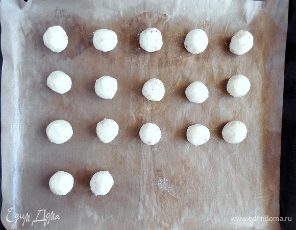Духовку разогреть до 180°С. Большой противень застелить ковриком для выпечки или очень хорошо смазанной растительным маслом бумагой для выпечки. Набирать по 1 ст. л. теста (без горки) и влажными руками скатывать из него шарики размером с грецкий орех. Должно получиться 16-17 шариков (один лишний крекер потом можно съесть и никому не говорить).