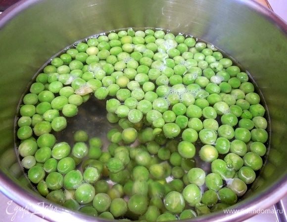 Пока выпекаются крекеры, приготовим зеленый хумус. 1 л воды подсолить и довести до кипения. Подготовить небольшую миску с ледяной водой. Всыпать замороженный горошек в кипящую воду и готовить 4 мин., пока горошек не станет мягким, но при этом будет все еще ярко-зеленым. 