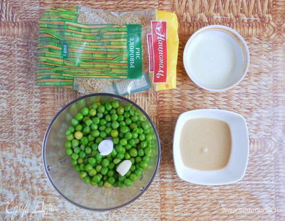 Слить холодную воду с горошка. В чашу блендера поместить горошек, лимонный сок, чеснок и тахини. Измельчить до однородности. Если масса будет слишком густой, добавьте немного воды от варки горошка (остывшей).