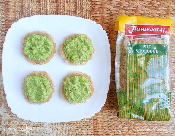 Остывшие крекеры аккуратно отделить от бумаги. 8 крекеров перевернуть и распределить поровну между ними зеленый хумус. 