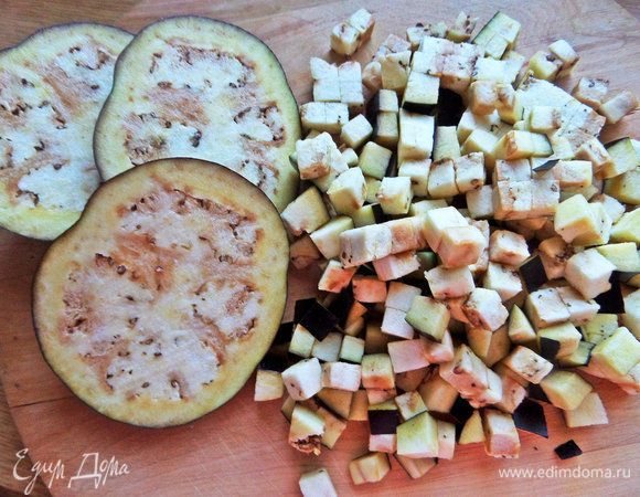 Баклажан нарезать на ломтики, затем порубить на кубики.