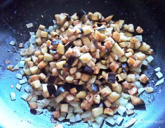 Баклажан слегка отжать от лишней влаги и высыпать к луку.