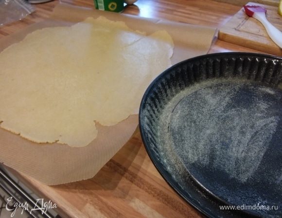 Сливы разрезать на половинки, удалить косточки. Вес слив дан в уже очищенном виде. Тесто раскатать прямо на пергаменте. Форму для тарта 26 см в диаметре смазать маслом и посыпать мукой или манкой. Выложить тесто в форму, пергаментом наверх. 