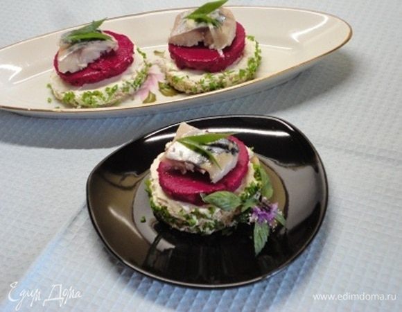 Если решили делать канапе круглой формы, стаканом вырежьте из хлеба (белый, серый или ржаной — выбирать вам. У меня ржаной хлеб с дижонской горчицей от Ярославы) кружочки. Творожный сыр — это мой выбор, можно ничем хлеб не смазывать или горчицей и т.п. Бока я тоже слегка смазала сыром, чтобы зелень держалась. Посуду с муссом на несколько секунд опустите в теплую воду, нарежьте и выложите на хлеб с сыром. Сверху — филе сельди. Все остальное — как подскажет вам фантазия. Закуска готова!