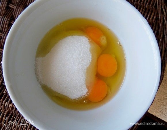 Готовим крем для смазывания листьев теста фило. В глубокую миску разбиваем 3 яйца, засыпаем сахар. 