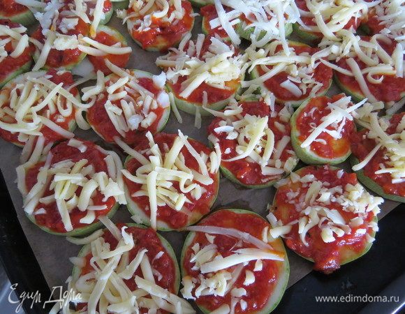 Смазать немного томатным соусом и сверху посыпать тертой моцареллой. Моцареллу можно заменить на другой сыр (но с ней нежнее), а томатный соус можно взять любой, хоть кетчуп.