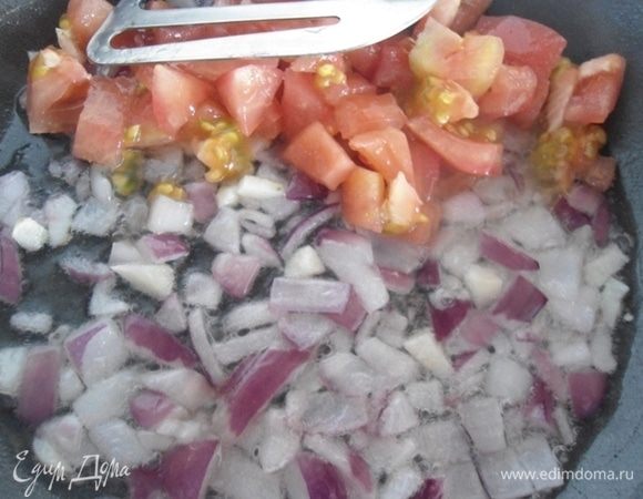 На растительном масле поджарить луковицу, через 2 минуты добавить нарезанный чеснок. Помидор очистить от кожицы, нарезать кубиками и  добавить к луку с чесноком. Добавить щепотку сахара для улучшения вкуса. Готовить 3-5 минут до готовности лука.