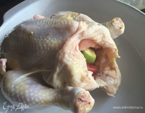 Начините курицу сливами и яблоками. Брюшко курицы зашейте или скрепите зубочисткой. Ножки свяжите кулинарной нитью.