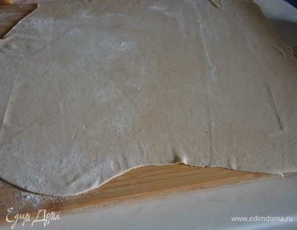 Раскатать тесто в тонкий пласт (до 1 мм). Для раскатки теста в рецепте указано еще 0,25 стакана пшеничной муки.
