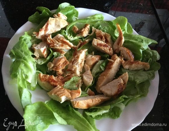 Куриную грудку нарежьте тонкими полосками и выложите на листья салата.