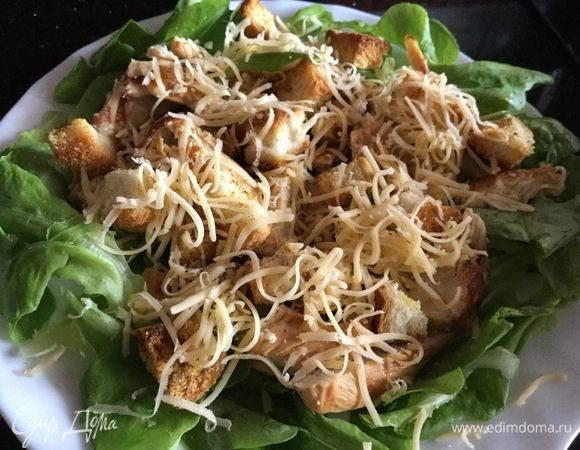 Сверху выложите сухарики и тертый сыр. Заправьте салат и подавайте. 