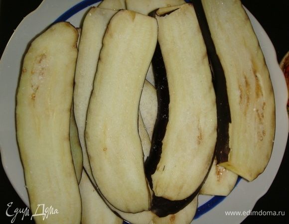 Баклажаны нарезать вдоль пластинками, посолить и оставить на 30 минут. После этого промыть их под водой и обсушить бумажными полотенцами.