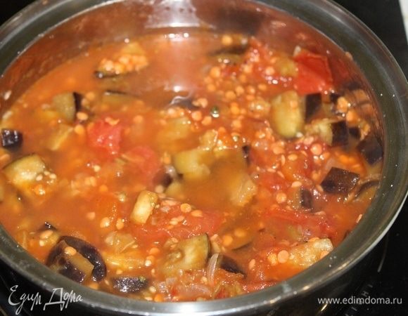 Перемешать и тушить пару минут, затем влить горячую воду. Довести до кипения, уменьшить огонь и продолжать готовить 10-15 минут.
