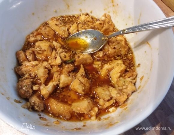 Для маринада соединить все ингредиенты. Чеснок растереть в кашицу. С чуть остывшей курицы снять шкурку, разорвать на кусочки и выложить в маринад, посыпать кунжутом и отставить в сторону. 