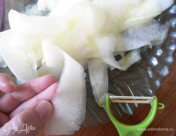 Цукини очистить и нарезать тонкими слайсами воспользовавшись овощечисткой.