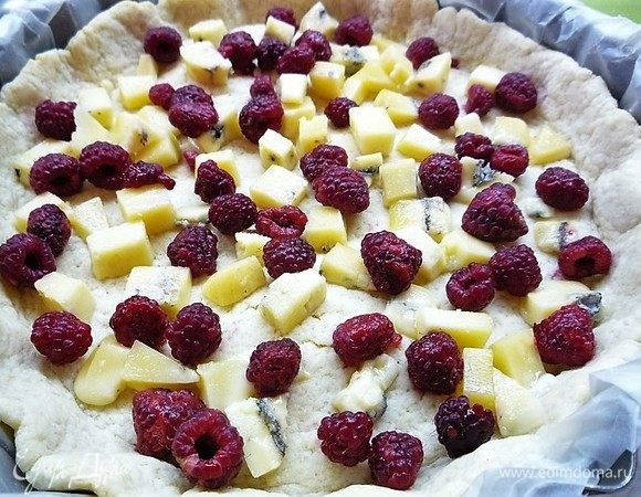На подпеченную песочную основу выкладываем малину и кусочки голубого сыра (у меня рокфорти).