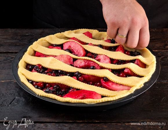 Возьмите еще часть теста, тонко раскатайте и нарежьте полосками шириной 1 см. Выложите полоски теста на пирог. Также по желанию можно вырезать из теста декоративные украшения для пирога. Оставьте пирог на 30 минут подняться. 