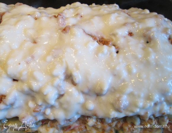 Верхний слой из соуса Бешамель. Отправляем заготовку в духовку, нагретую до 200°С на 35-40 минут, посыпав тертым сыром.