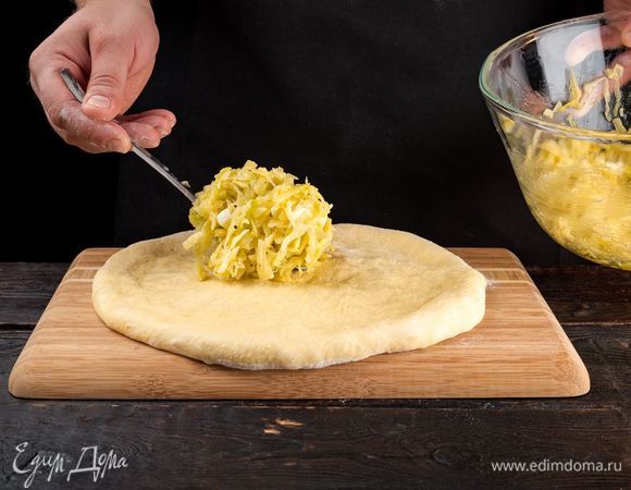 Выложите тесто, придайте ему форму круга, выложите начинку.