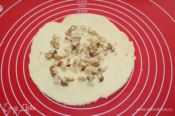 Тесто разделите на 4 части и раскатайте диаметром 12 см, выложите орехи.
