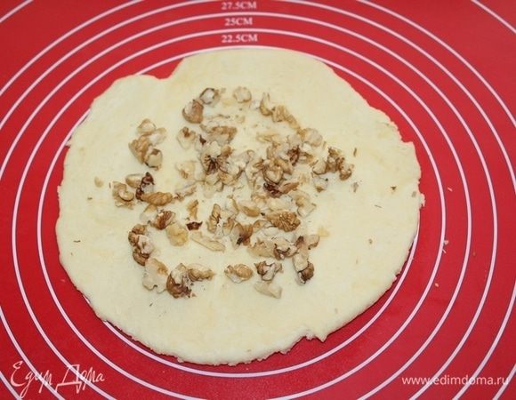 Тесто разделите на 4 части и раскатайте диаметром 12 см, выложите орехи.