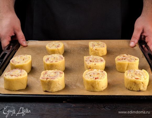 Выложите пирожки на застеленный пекарской бумагой противень. Выпекайте в заранее разогретой до 180°С духовке 30 минут. 

