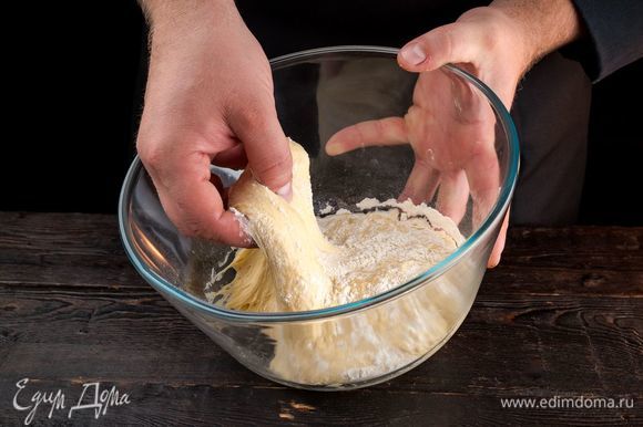 Когда опара поднимется, постепенно добавьте оставшуюся муку и вымесите тесто. Накройте тесто полотенцем и оставьте подходить еще на 15 минут.