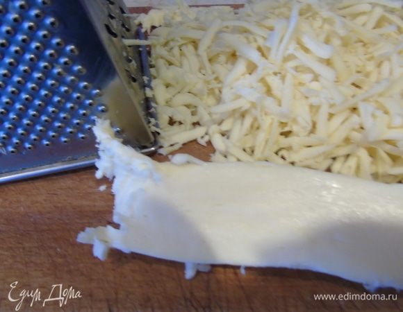 Пока основа выпекается, натираем сулугуни.