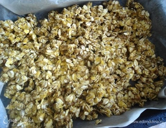Смешать сухие и влажные продукты вместе. Форму выстелить пергаментом и распределить гранолу по форме. 