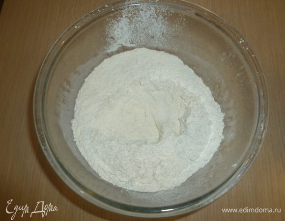 Муку просеять, смешать с солью, сделать небольшое углубление. Вылить воду с дрожжами, добавить оливковое масло и замесить тесто. Вымешивать, пока тесто не станет эластичным. 