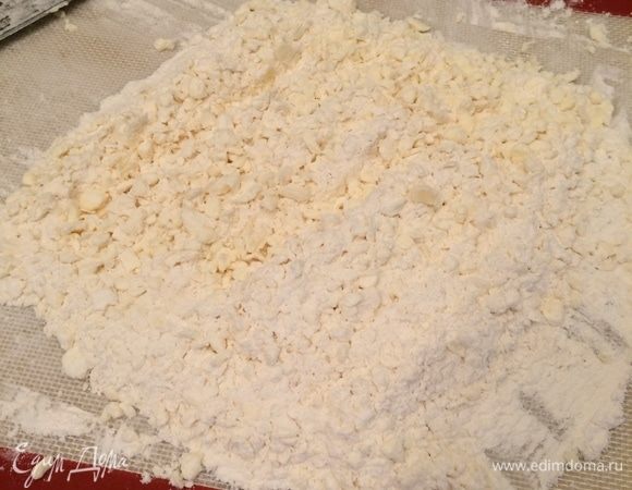 Готовим тесто. Муку смешать с солью, высыпать на силиконовый коврик. Нарезать холодное сливочное масло кусочками в мучную смесь и порубить масло, смешивая с мукой. Должна получиться жирная крошка. Переложить в емкость, добавлять по 1 ст. л. ледяную воду, замешать тесто. Запечатать тесто в пищевую пленку и поместить в холодильник минимум на 3 часа.