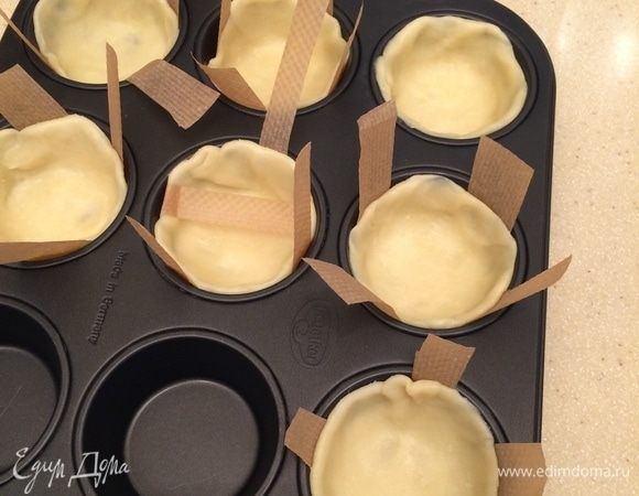 Тесто раскатать в тонкий пласт, вырезать круги, уложить в металлическую форму для выпечки маффинов.