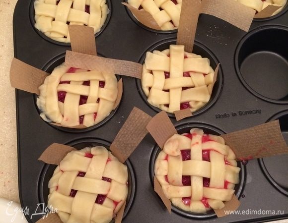 Выложить вишневую начинку. Из остатков теста раскатать пласт, нарезать полоски, выложить поверх каждого пирога решетку.