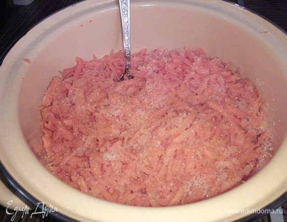 Промоем и очистим морковь. Далее натрем ее на мелкой терке, положим в подходящего размера емкость, засыпем сахаром, закроем крышкой. Если морковь свежая и сочная, даст сок быстро. Если нет, оставляем на ночь. 